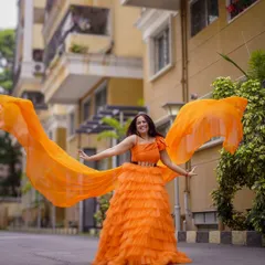 A burst of sunshine. This client is having a blast twirling in this vibrant orange ruffle gown.