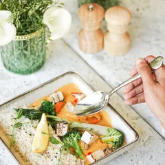 A comforting bowl of our Asian-inspired curry, served with rice and loaded with fresh vegetables like broccoli and carrots. It's a flavorful and wholesome meal.