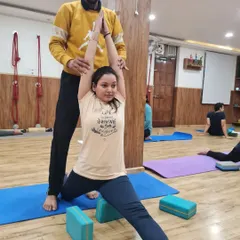In this supported lunge, we use blocks to elevate the hips, making the stretch more accessible. I am helping the student lift and lengthen through her torso to create space before folding forward.