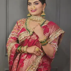 A beautiful bride in a pink Paithani saree. The makeup is bright and festive, with a focus on glowing skin and eyes that sparkle.