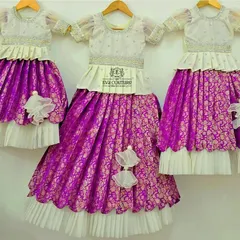 A beautiful set of three matching Banarasi lehengas in white and purple, created for three sisters to wear at a family function.