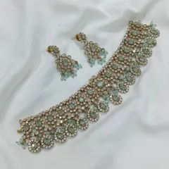 A beautiful choker set with pastel blue stones and a gold finish. This piece is perfect for pairing with modern lehengas or sarees for a subtle, elegant look.