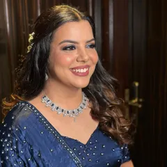 This bride's cocktail glam is on point with a dramatic smoky eye and a defined lip. The hairstyle is kept soft with curls to balance the bold makeup.