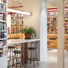 We designed the Penguin India office with a variety of seating options to support different work styles. This high-top coffee bar provides a casual spot for quick meetings or focused work, surrounded by floor-to-ceiling bookshelves that reinforce the company's literary identity.