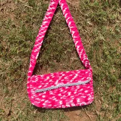A product shot of the pink and white messenger bag. It has a long strap so you can wear it cross-body or on your shoulder.