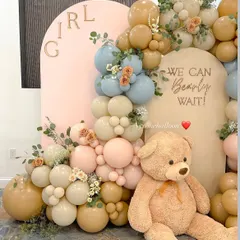 The teddy bear theme is a classic for a reason. Here is a gender reveal setup with the message 'We Can Bearly Wait', using a soft, modern palette of muted blue, pink, and beige balloons.