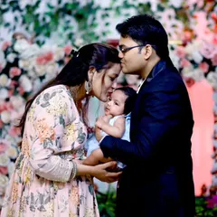 The purest form of love. This photo captures the new parents gently kissing their baby's head during the naming ceremony, a memory to be cherished forever.