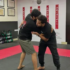 Two students practice a standing clinch, working on the initial phase of a takedown. Our grappling classes cover techniques for both standing and ground situations.