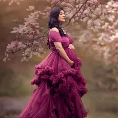 This shot looks so divine. The rich wine color of this ruffled maternity gown stands out beautifully against the soft, natural background. It’s an off-shoulder design that adds a touch of romance to your pregnancy photos.