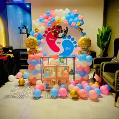 A classic "Boy or Girl" gender reveal setup. The backdrop with blue and pink footprints creates the perfect suspense, complemented by balloon pillars, 'BABY' blocks, and foil baby balloons.