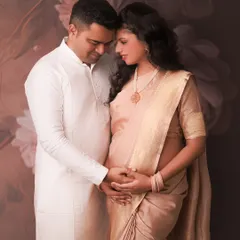 The combination of a soft saree for her and a classic kurta for him creates such a harmonious and elegant portrait. This image speaks of their quiet connection and shared anticipation.