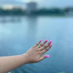 Another shot of these amazing neon pink nails against a beautiful water background. This color truly pops and is perfect for making a bold statement.