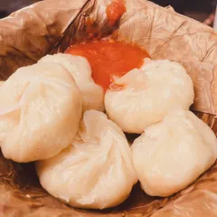 Our freshly steamed vegetable momos served in an eco-friendly leaf bowl with a side of spicy red chutney. They are soft, juicy, and packed with flavor.