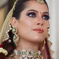 A close-up shot of a finished bridal makeup look. You can see the intricate eye makeup, perfectly blended skin, and how the makeup complements the beautiful jewelry and outfit.