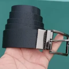 This is my reversible leather belt, held to show the high-quality buckle and the textured black leather.