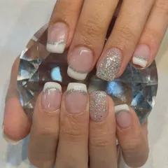A glamorous take on the French manicure. This design features a classic white tip accented with a fine line of silver glitter and a full glitter accent nail for extra sparkle.