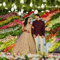 A wider angle of the spectacular floral wall, showing the couple surrounded by a rainbow of blooms. This kind of backdrop makes for truly unforgettable wedding photos.