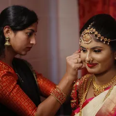A candid moment of me ensuring the bride's jewellery and bindi are perfectly placed. My process is meticulous because every single detail contributes to the final flawless look.