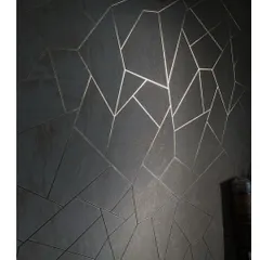 This dark wallpaper with an irregular geometric line pattern in gold is a bold and luxurious choice. It adds a very modern, almost futuristic feel to the wall.