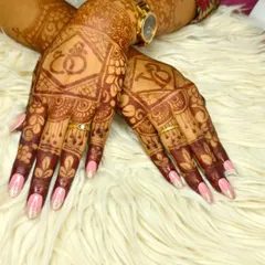 Elegant pink gel polish with a glitter fade, perfectly complementing intricate bridal henna. A beautiful choice for wedding festivities.