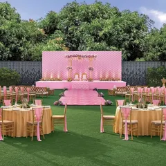 The Vidhi Mandap for the pastel lawn wedding. The stage features a quilted pink backdrop and delicate floral arrangements, creating a soft and romantic focus point for the ceremony.