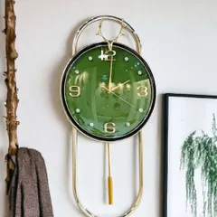 This imported wall clock features a rich green face with classic gold numerals and a deer-head crest. The elegant pendulum design and polished metal frame make it a sophisticated choice for both modern and traditional interiors.