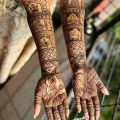 A masterpiece for a beautiful bride. This full bridal mehendi is a classic example of traditional design, filled with intricate patterns, portraits, and auspicious symbols like the kalash and Ganesha for a blessed beginning.