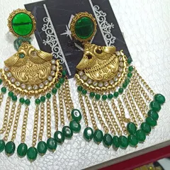 These antique gold finish earrings feature a peacock design with green stones and hanging chains. They are a perfect example of traditional temple jewellery design, ideal for wearing with sarees.