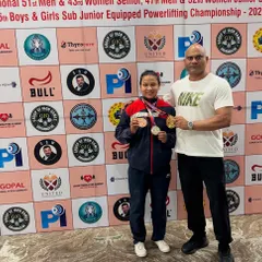 I don't just train lifters; I build champions. Here I am with my student Beena Parihar, celebrating her gold medals at the Junior National Powerlifting Championship. She set two national records, a testament to her hard work.