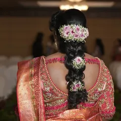 The back view of a bride's blouse, featuring an intricate cutout design bordered with delicate pearl and thread work. It’s a stunning detail that adds an element of surprise and sophistication.