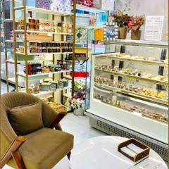 A cozy corner of our showroom featuring a comfortable chair and a display of our gourmet treats and smaller gift items. This highlights the retail experience we offer to our walk-in customers.