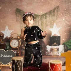 A sweet and curious pose from Ivaana's first birthday session. The '1' and personalized chalkboard are perfect props for milestone shoots.