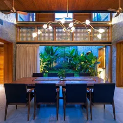 A view from the dining room into the illuminated courtyard at night. The landscape lighting design turns the garden into a stunning feature after dark, providing a beautiful backdrop for evening meals and entertaining.