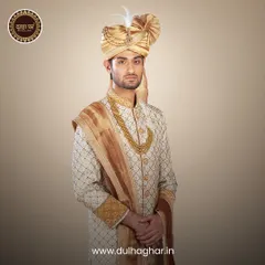 Here is an outfit that turns moments into memories. A complete groom's look featuring a cream sherwani, a golden safa, and a multi-layered pearl necklace, designed to give you a truly royal presence.