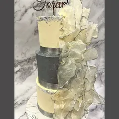 Modern sophistication for an engagement party. This three-tier cake combines a sleek grey middle tier with textured buttercream and a dramatic cascade of edible wafer paper sails.