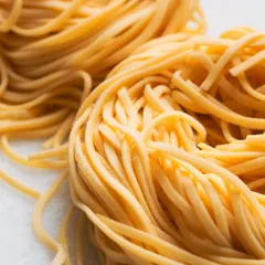 A macro shot of nests of fresh, uncooked pasta. The abstract quality and focus on texture offer a different perspective on a familiar food.