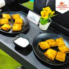 Our appetizer menu includes a variety of fusion items like these crispy Pizza Pockets. They are a perfect bite-sized snack for weddings and parties, served hot with a creamy dip.