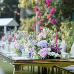 A close-up of the floral centerpiece running down the table. I used a mix of hydrangeas, lilies, and other flowers in shades of purple, pink, and white to create a soft and romantic look.