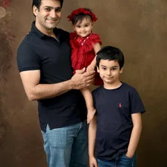 A proud father with his two children. He holds his baby girl while his son stands beside him, creating a strong and loving portrait of a dad with his kids.
