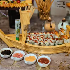 I bring global flavors to your table with artistically presented dishes like this handcrafted sushi boat. It's a perfect centerpiece for birthdays and corporate events, complete with wasabi, soy sauce, and pickled ginger.