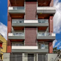A direct front elevation of 'Vihaan,' detailing the symmetrical arrangement of brickwork, jali screens, and recessed balconies.