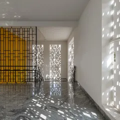 At Vidyashilp Academy, I used large, jali-inspired facade panels to filter sunlight and create a dynamic play of light and shadow. This passive design strategy not only ensures constant airflow and reduces heat but also turns a simple corridor into an ever-changing canvas of patterns.