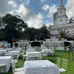 The pristine white table setup against the backdrop of a historic building, showcasing the grand scale of events I cater.