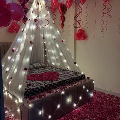 The combination of balloons, lights, and petals makes for an unforgettable romantic gesture.