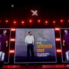 A powerful stage setup for a political event celebrating Amit Thackeray's birthday. It features a central large LED screen flanked by two vertical LED panels, creating a visually dominant and impressive display.