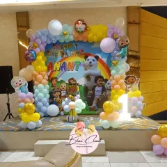 This Cocomelon party setup includes a personalized backdrop with the birthday boy's photo. We framed it with a pastel balloon arch and character cutouts to create a complete themed look.