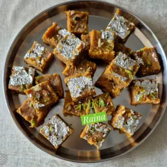 My Moong Daal Barfi, decorated with pure silver vark, is a festive favorite. I roast the lentils for hours in pure ghee to achieve that perfect golden color and rich, melt-in-your-mouth texture.