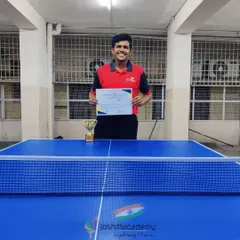 Celebrating Praneet, our inter-college table tennis champion. He stands proudly with his certificate and trophy, representing the success our players achieve at every level.