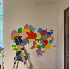 The beginning of a mural is like a blank page. For the 'Freedom Mural,' I started by blocking out the main color fields. This helps me map out the energy and movement of the piece before diving into the details.