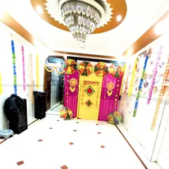 A fisheye lens view of the Haldi setup, capturing the entire festive corner from the ornate chandelier to the decorated floor.